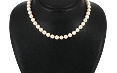 A pearl necklace set with numerous Akoya cultured pearls and a clasp...