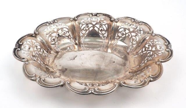 A pierced Edwardian silver cake basket, Chester, 1904, Thomas Latham & Ernest Morton, of oval form with shaped scroll border and four trefoil shouldered feet, 30.5cm long, approx. weight 15.7oz