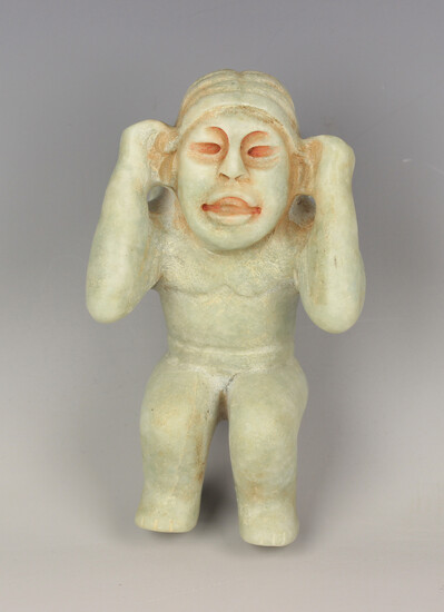 A pre-Columbian Olmec style carved pale green hardstone figure of a water carrier, probably 900-450