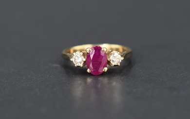 A ruby and diamond trilogy ring, the central oval cut ruby, approx 0.70ct, flanked by two
