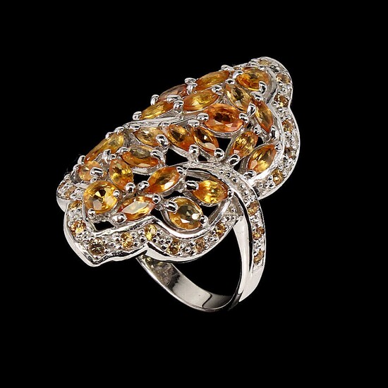 A sapphire ring set with numeropus oval and navette-cut orange and yellow sapphires, mounted in rhodium plated sterling silver. Size 58.