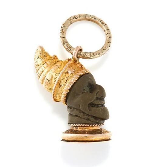AN ANTIQUE CARVED LAVA PENDANT in yellow gold, designed