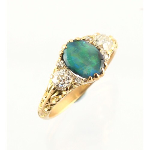 An 18ct gold black opal & diamond ring, the oval black opal ...