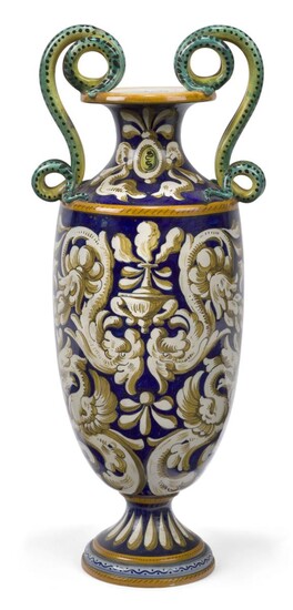 An Italian Colonnata majolica amphora, early 20th century, with scrolling snake form twin handles to the neck, decorated with Classical motifs to a cobalt blue ground, with centrally placed cartouche with cherub mask featuring a mythical beast...