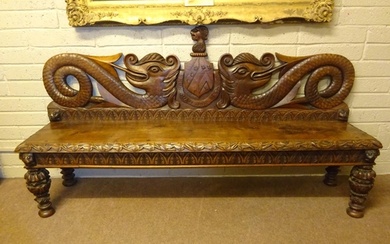 An antique carved walnut hall bench, the back with a central...
