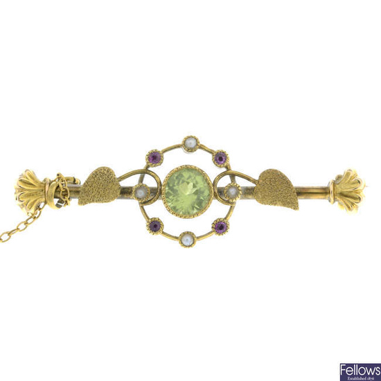 An early 20th century 15ct gold peridot, split pearl and ruby foliate bar brooch.