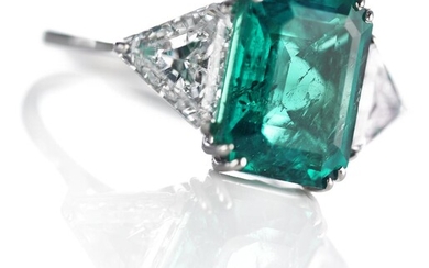 An emerald and diamond ring set with an emerald-cut Colombian emerald weighing...