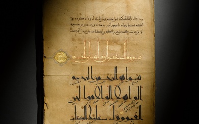 An illuminated Qur’an section in Eastern Kufic script with commentary,...