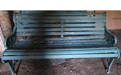 An old garden bench with painted wooden slatted seat and com...