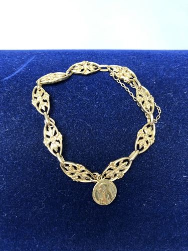 Bracelet en or jaune avec médaille. P. 18...