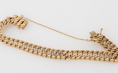 Bracelet gourmette en or jaune 18 K avec chainette de sécurité . Poids : 15,35...