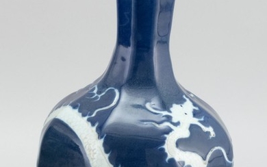 CHINESE WHITE-ON-BLUE PORCELAIN VASE Octagonal, with a white dragon and pearl design on a blue ground. Height 12.7".