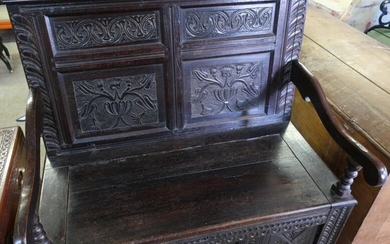 Carved dark oak hall bench with four carved panels...