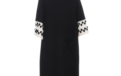 Chanel: A black wool blend dress with short sleeves, a rounded neck line, two pockets on the front and white rims with black polka dots. Size 40 (FR)