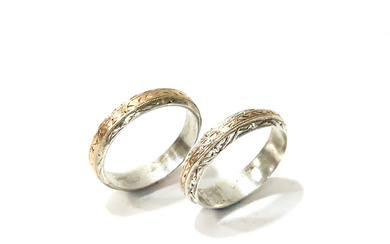 PAIR OF SILVER ENGAGEMENT RINGS WITH YELLOW GOLD VIEWS.
