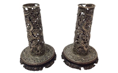 Pair of Chinese white metal candlesticks with pierced dragon decoration on carved wood bases