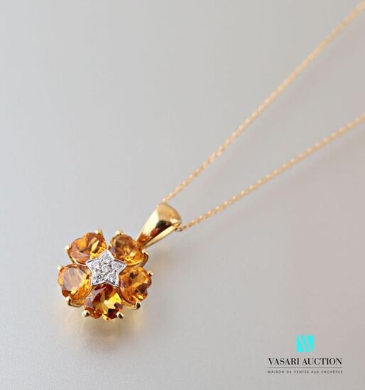 Pendant and its chain in 750 thousandths yellow gold, the flower-shaped pendant is decorated in its center with a star paved with modern cut diamonds, the petals set with five heart-shaped citrine.