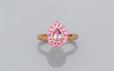 Ring drawing a pear-shaped platter in yellow gold, 750 MM, centered of a pear-cut pink sapphire in a row of brilliants surrounded by round pink sapphires, 10 x 13 mm, size: 54, weight: 4.15gr. gross.