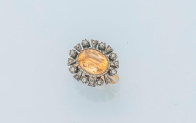 Ring in 18 karat yellow gold (750 thousandths) and silver (800 thousandths), adorned with an oval-shaped citrine of approximately 2.5 carats in an entourage of rose-cut diamonds.