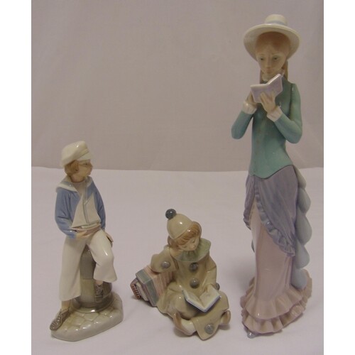 Three Lladro figurines to include a young boy with a boat, a...