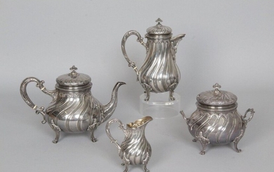 Three-piece silver 950 thousandths service in the form of a baluster with torsos gadroons and combed friezes resting on four scrolled feet and leafy attachments, the button fretels topped with pearls. Goldsmith: GUERCHET (punch of the goldsmith on the...