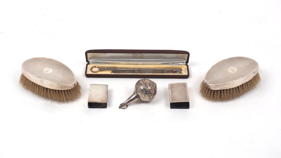 Two silver match box holders, one Birmingham, 1931, James Dixon & Sons, the other London, 1954, with presentation engraving, together with a silver paper knife with fox head surmount, a further silver paper knife, a white metal child's rattle...