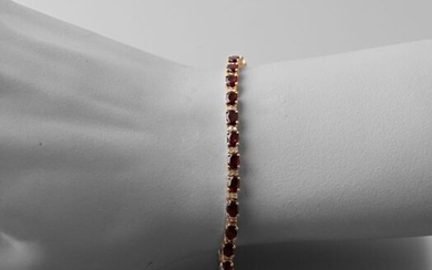 Vermeil line bracelet adorned with oval-cut garnet alternating with round diamonds, the clasp snap hook.