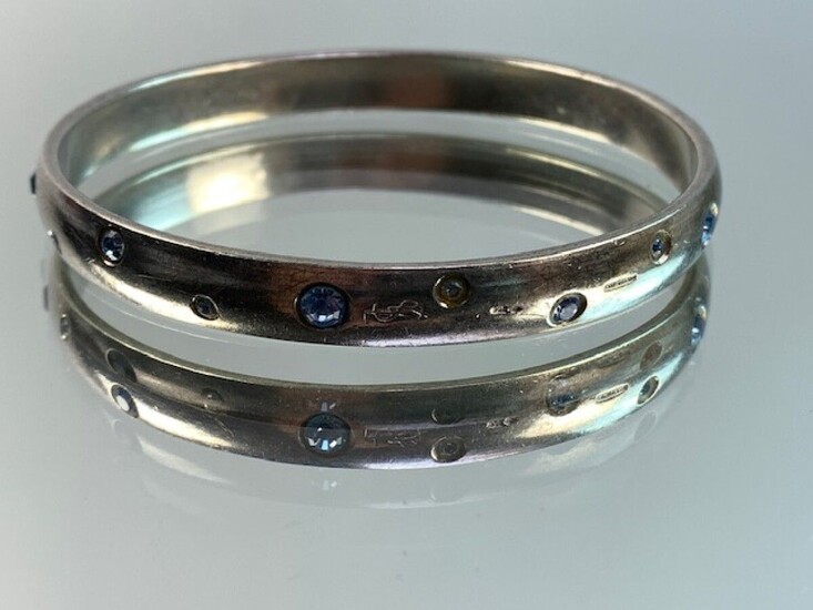YVES SAINT LAURENT- Bracelet YSL en argent orné de strass bleu. PB: 40, 8 grs...