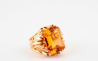 Yellow gold ring (750), the raised bezel openworked centered with a synthetic orange sapphire cut in degrees in claw setting.