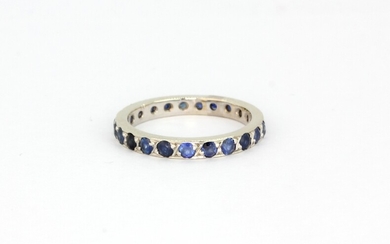 A 14ct white gold (stamped 585) sapphire set full eternity ring, (L).