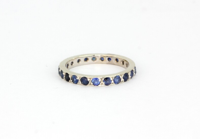 A 14ct white gold (stamped 585) sapphire set full eternity ring, (L).