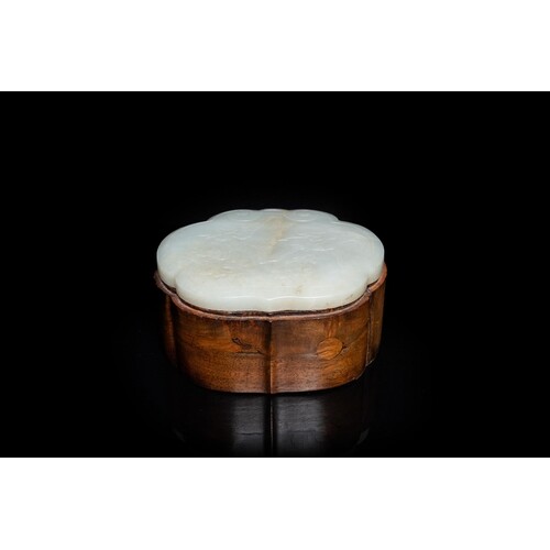 A Chinese wooden box with a white jade 'ruyi' plaque as cove...