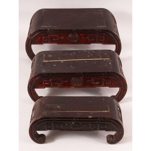 A GRADUATED SET OF THREE CHINESE HARDWOOD STANDS, each with ...