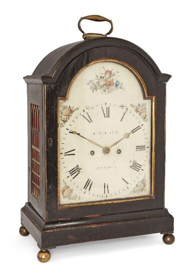 A George III ebonised bracket clock, by T. McCaeb, early 19th century, the ebonised case with break arch top with brass handle, having brass fish scale fretwork side panels, on plinth base and brass ball feet, the broken arched painted dial with...