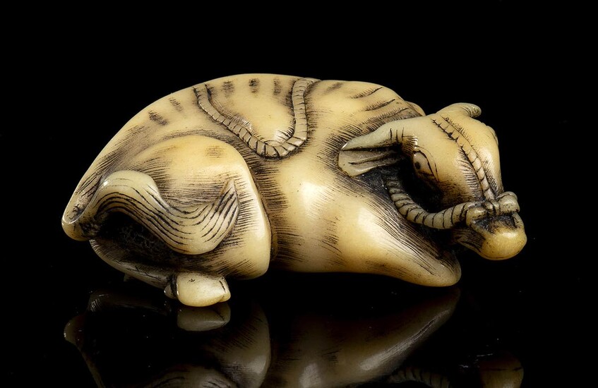 A HORN NETSUKE WITH A RECUMBENT OX Japan, 19th...