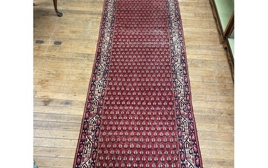 A Persian red ground rug, 322 x 107 cm