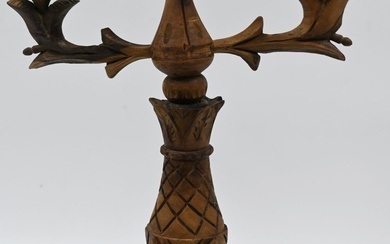 A candlestick made of olive wood painted dark brown....