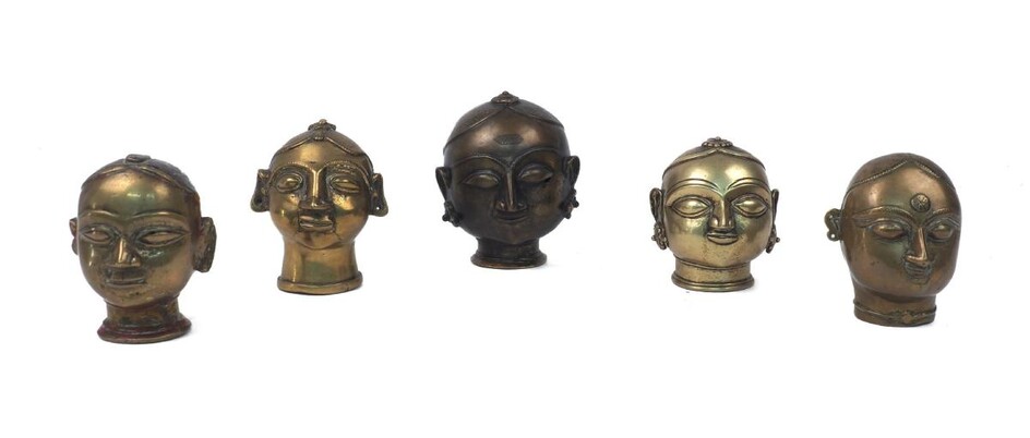 A group of Indian brass heads, 19th century or earlier, Hindu, depicting Gauri, one with remnants of paint, each with typical almond eyes, 9.5cm to 12.5cm high (5)