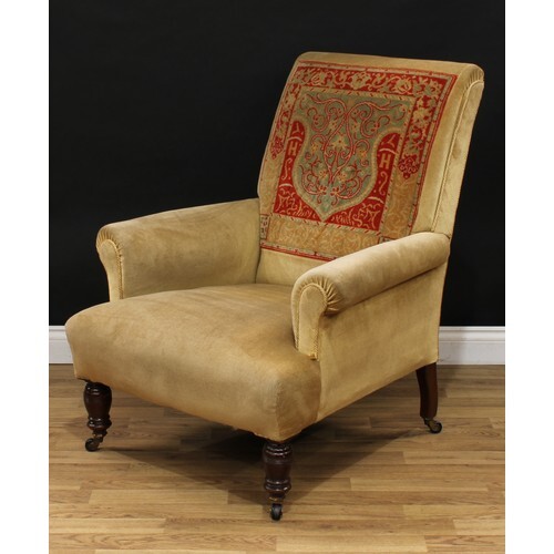 A late Victorian 'carpet' armchair, scroll arms, stuffed-ove...