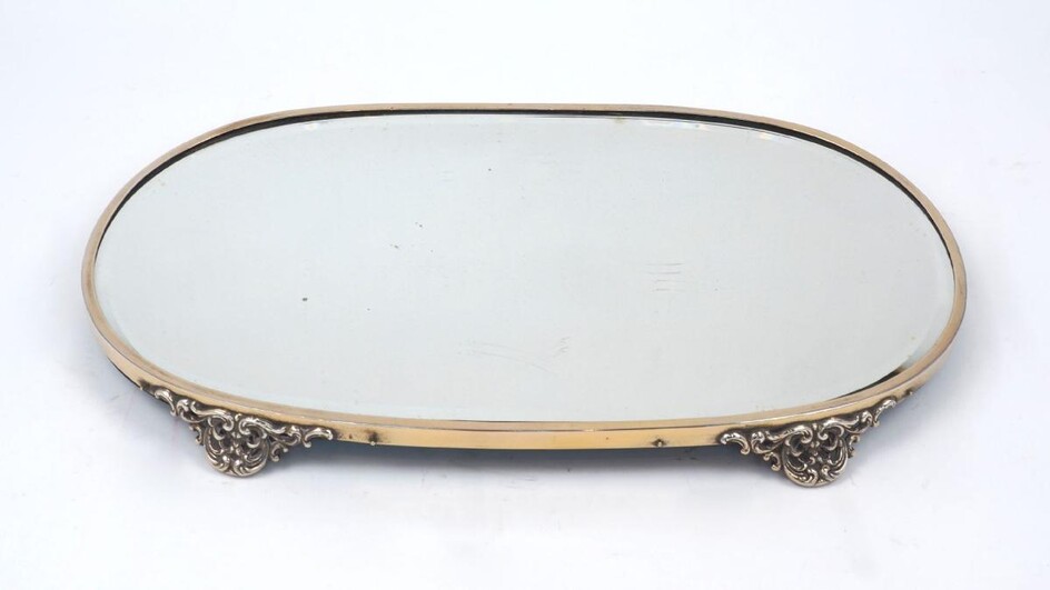 A mirrored surtout-de-table, of oval form, with silver plated surround and pierced bracket feet, 46cm long, 17cm wide