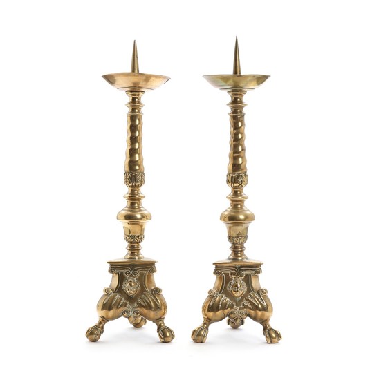 A pair of Baroque style brass spike tip candlesticks, triangular base, raised on paw feet. 19th century. H. 57 cm. (2)
