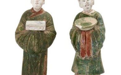A pair of Chinese sancai-glazed pottery funerary figures, Ming Dynasty, each standing on an hexagonal base and with detachable head, the tallest 48cm high (2). 明 陶三彩人像兩尊