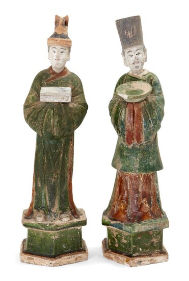 A pair of Chinese sancai-glazed pottery funerary figures, Ming Dynasty, each standing on an hexagonal base and with detachable head, the tallest 48cm high (2). 明 陶三彩人像兩尊