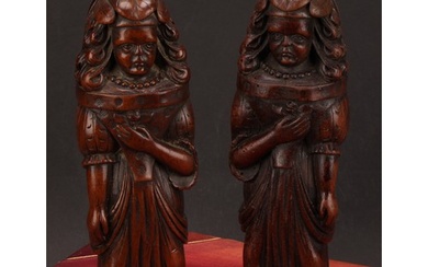 A pair of Continental walnut appliques, each carved as a lad...