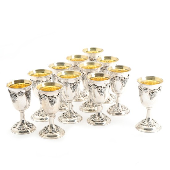A set of 12 silver, 900 standard, goblets forged with grapevines and clusters of grapes, gilt interior. Marked. H. 15 cm. (12)