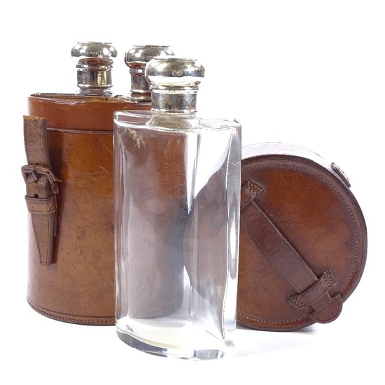 A set of 3 cut-glass silver-topped spirit bottles in origina...