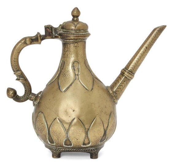 A small Mughal engraved brass lidded ewer with moulded leaf...