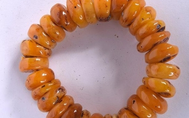 AN AMBER BRACELET, formed with flattened beads. 9 cm