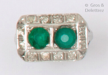 A chased white gold ring set with two green stones in a ring of old cut diamonds. Art Deco period work. Finger size : 53. P. Brut: 6.4g. (One stone missing)