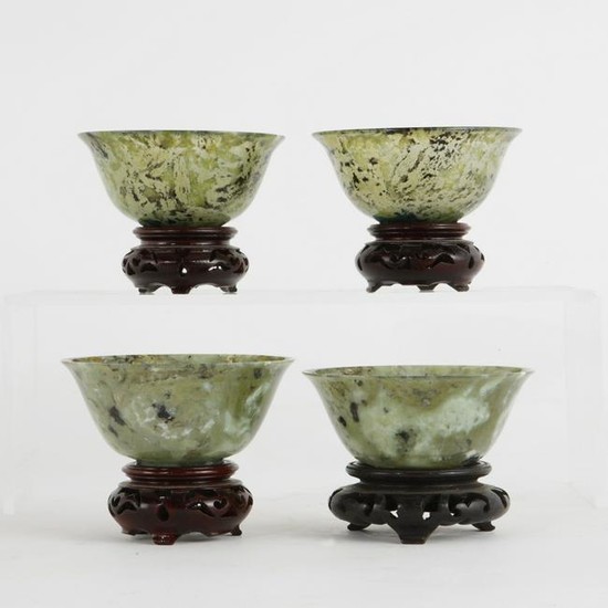 Four Chinese hardstone bowls on wood stands